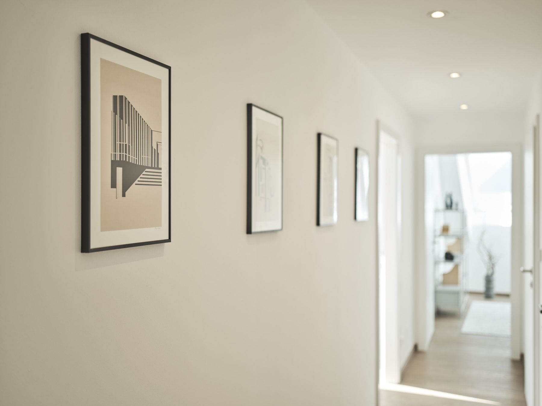 Vorzimmer mit weißen Wänden und weißen Türen, 4erSet schwarz-weiße Grafiken an der Wand - Blick ins Gästezimmer