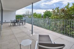 Blick von der Terrasse - mit Liege und Beistelltisch - ins Grüne - alter Baumbestand, Balkongeländer aus Metall