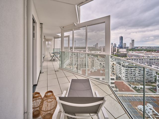 Terrasse mit Klapptisch und Klappstühlen in blauem Metall - und Blick über Wien