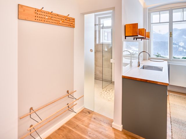Vorzimmer mit Holz-Wandgarderobe, Schuhregal, Blick ins Bad und in die Küche