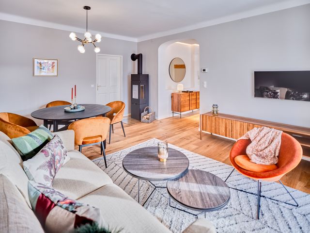 Wohnzimmer mit Schlafsofa, TV Board, Esstisch, Stühlen und Holzofen